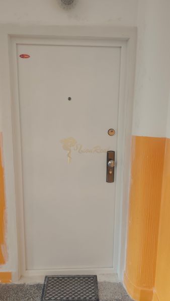 White doors in the hallway of a 4-room apartment with orange walls.