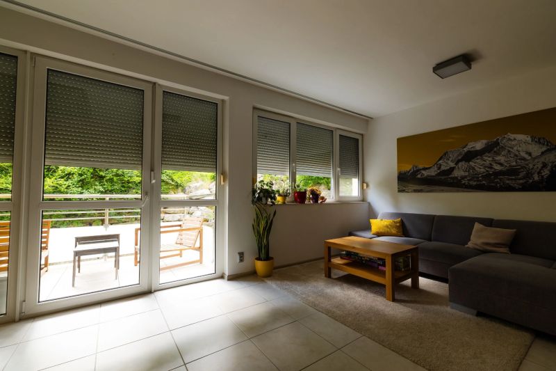 Living room in a two-room apartment with a sofa, table, and a view of the terrace.