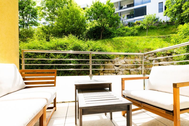 Outdoor seating on the terrace of a 2-room apartment with a view of greenery in Bratislava.
