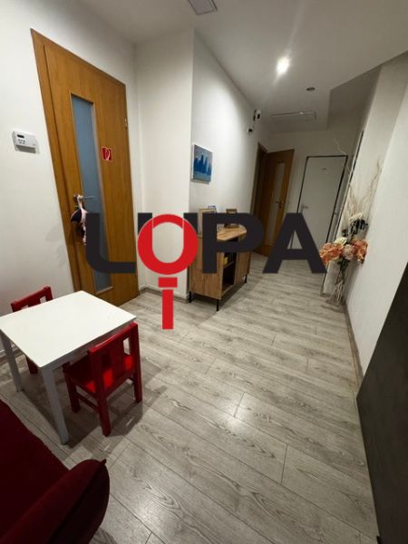 Interior of commercial premises with wood-patterned flooring and a children's corner.