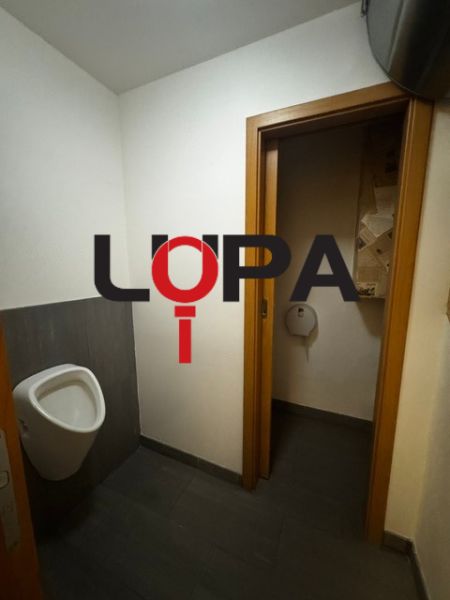 Interior of commercial premises with a toilet and dark flooring with a wooden decor.