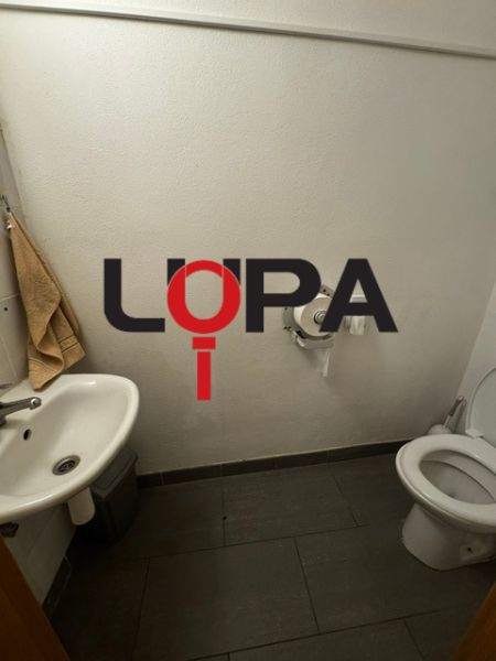 Toilet with a sink and tiles. Commercial premises with simple equipment.