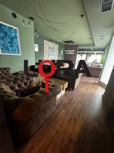 Interior of commercial spaces with comfortable sofas and wood-patterned flooring.
