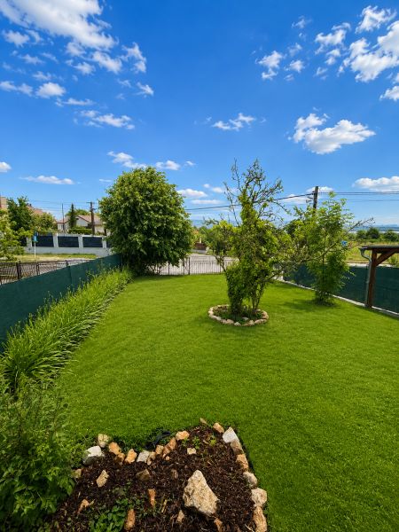 A garden at a family house in Šalgovce with a well-maintained lawn and flower beds.