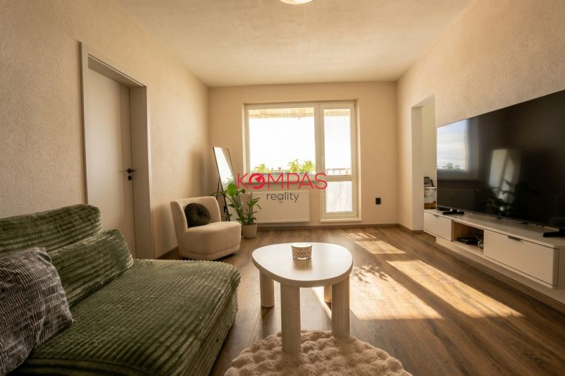 Living room in a two-room apartment with a wooden decor floor and comfortable furniture.