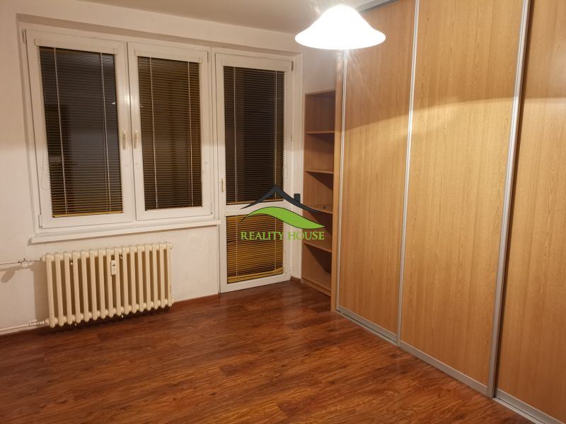 A room with a wooden floor decor and a large built-in wardrobe in a 3-room apartment.
