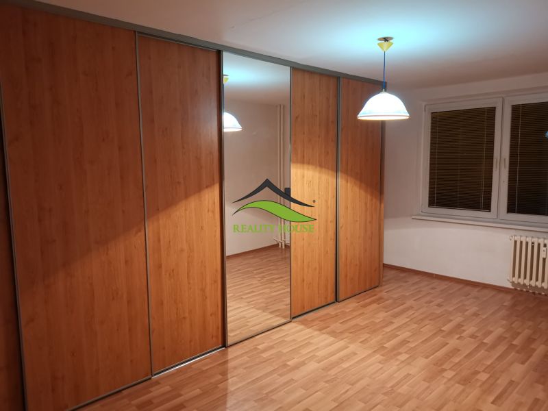 A wardrobe with sliding doors, a mirror, and a floor with a wooden decor in a 3-room apartment.