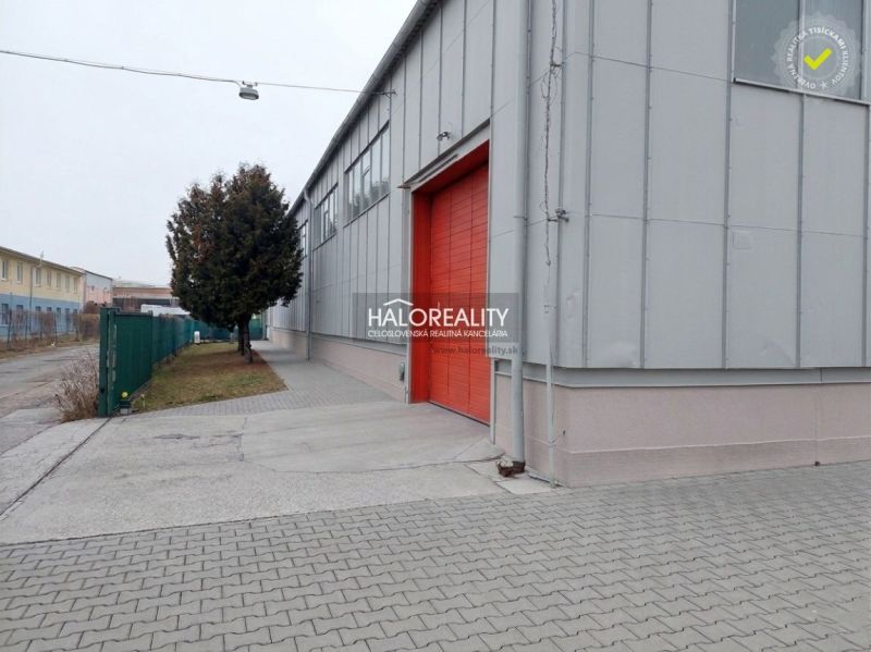 The exterior of offices in KE - Džungľa with red doors and a paved walkway.