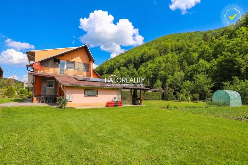 A family house in Dolná Mariková with a lawn and surrounding greenery.