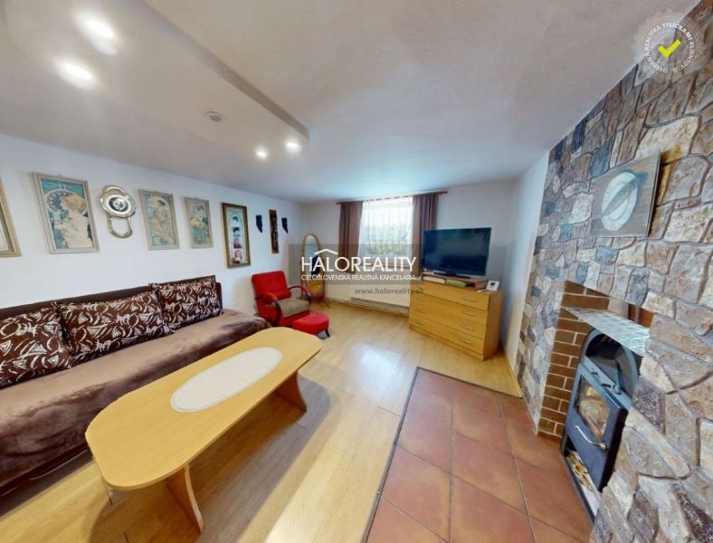 Living room in a family house with a stone fireplace and a floor with a wooden decor.