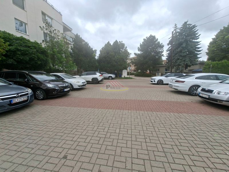Parking lot with cars on Športová Street in Dunajská Lužná in front of the building.