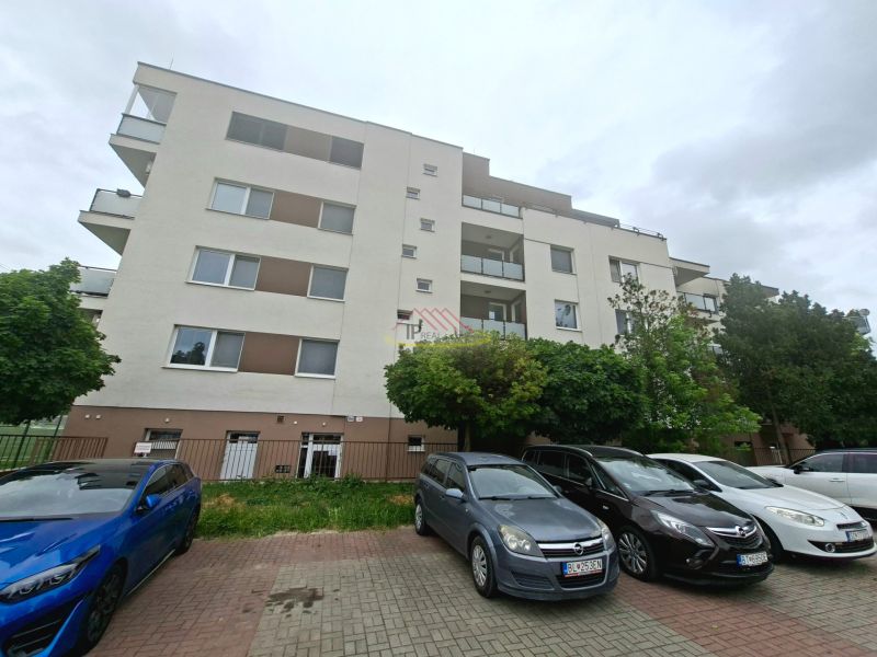 Apartment building on Športová Street in Dunajská Lužná with a parking lot and cars in front of the building.