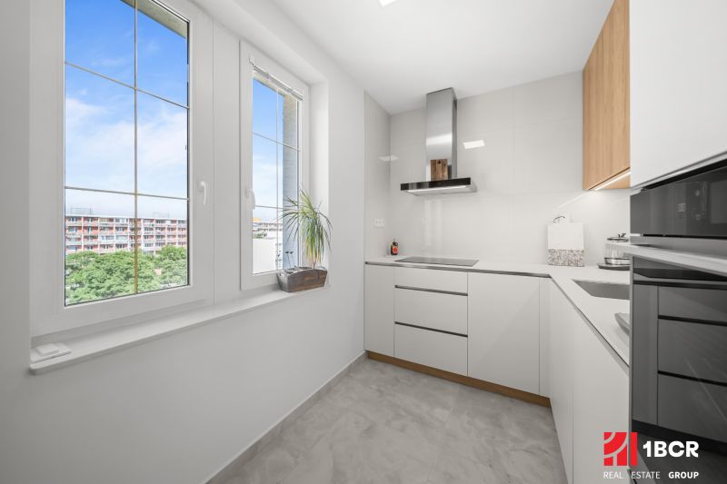 A bright kitchen in a 3-room apartment with windows and modern appliances.