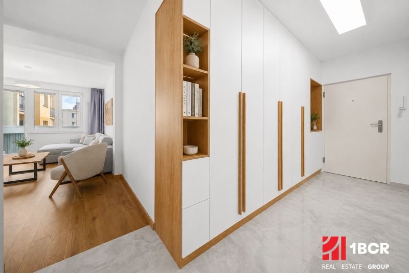 Living room with wood-patterned flooring and a built-in wardrobe in a 3-room apartment.