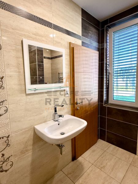 A modern bathroom in a family house with a sink and a mirror on the wall.