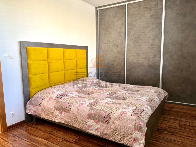 Bedroom in a family house with a bed and a wardrobe, floor with wooden decor.