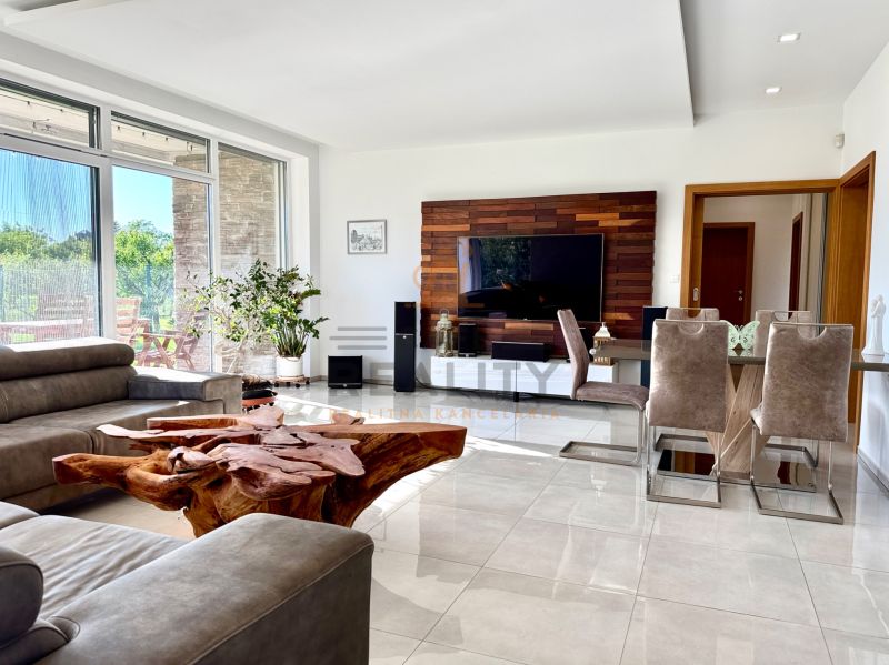 Living room in a family house with a leather sofa, unique wooden table, and television.