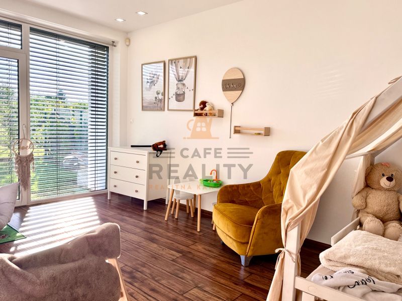 Children's room in a family house with a wooden decor floor and a large window.