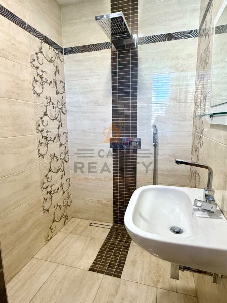 A bathroom in a family house with decorative tiles and a stylish sink.