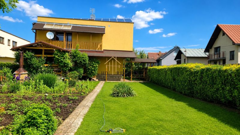 A garden and a family house in Slovenská Ľupča with a manicured lawn and flower beds.