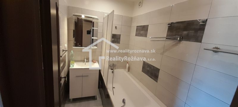 Bathroom in a 2-room apartment with a bathtub and a washbasin cabinet.