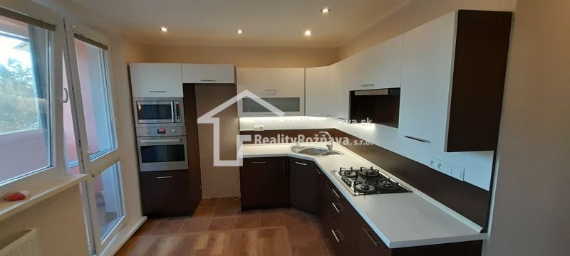 A kitchen in a 2-room apartment with a wood-decor floor and built-in appliances.
