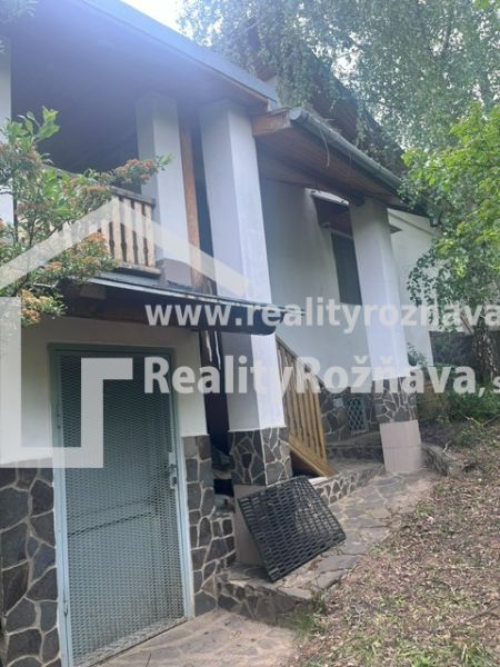 A cottage in Jablonov nad Turňou, surrounded by greenery, with a terrace and stone cladding.