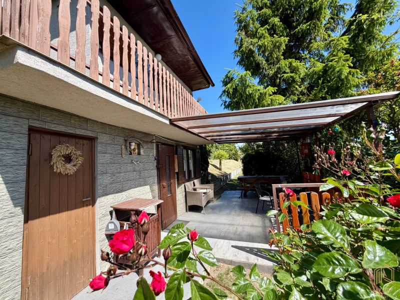 A cottage in Kunov near Senica with a wooden balcony and a romantic terrace full of flowers.