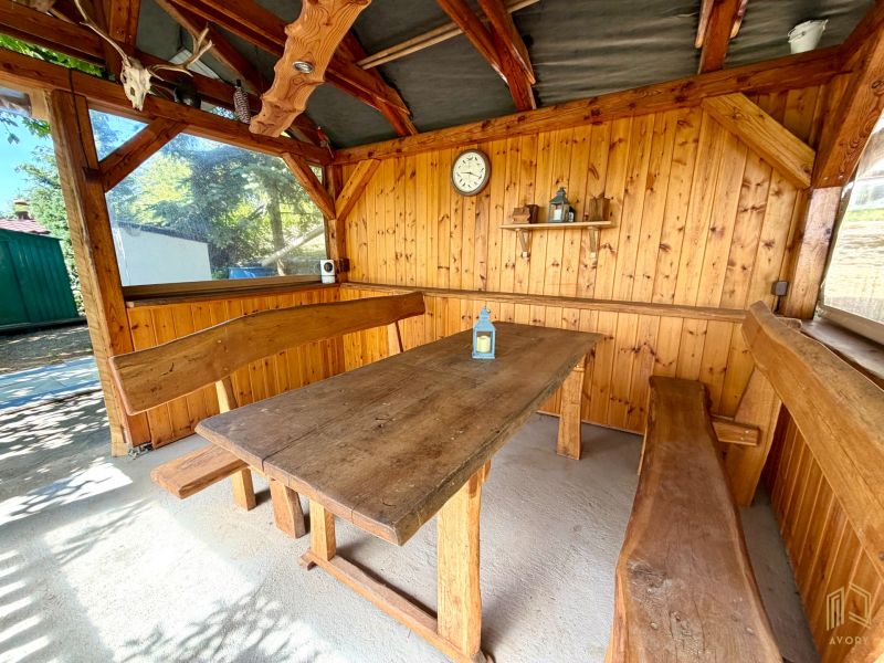 A wooden cabin with a massive table and benches offers a cozy seating area.