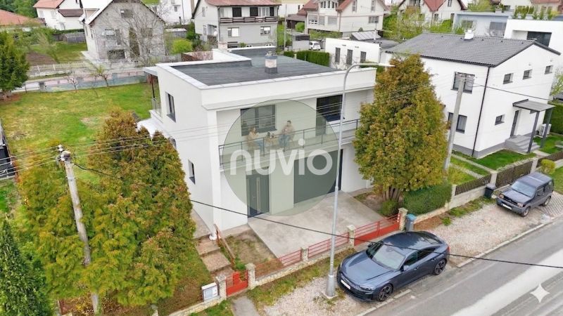 A family house in Martin with a flat roof, with a car parked next to it.