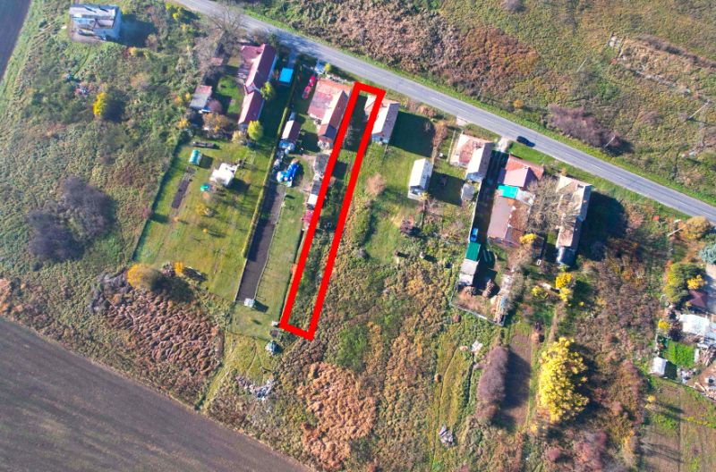 A top-down view of residential plots in Radnovce, surrounded by nature and a nearby road.