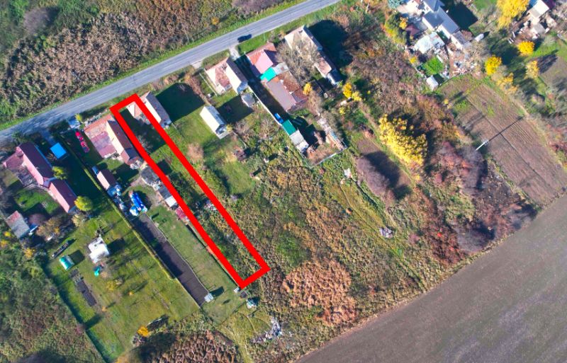 Aerial perspective of residential plots in the village of Radnovce with the main road.