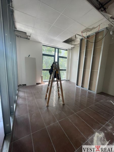 Offices with a ladder and an unfinished ceiling, floor with wood decor.