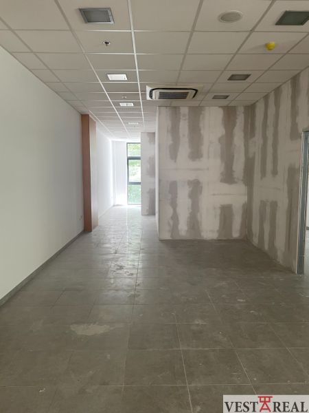 Offices with glass windows and tiled floors, ceiling with integrated air conditioning.