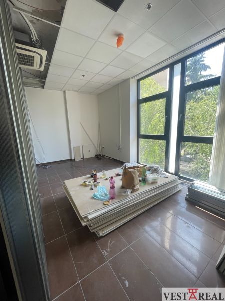 Offices with large windows, air conditioning, and clutter, with a wooden decor floor.
