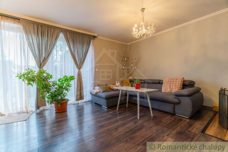 Living room in a family house with a sofa and wooden decor flooring.