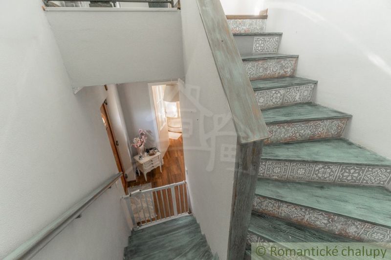 A staircase in a family house with decorative patterns and a floor with a wooden decor.