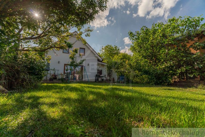 A family house in Bernolákovo surrounded by a garden with greenery and trees.