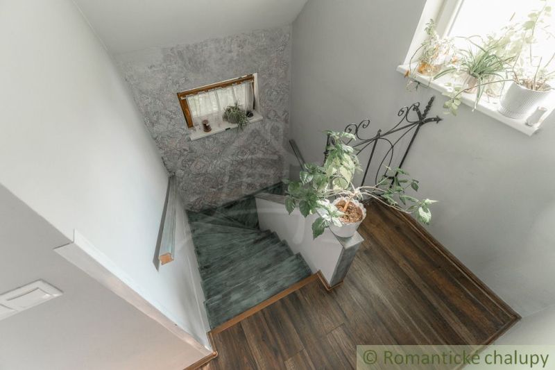 A staircase in a family house with flowers and a wooden decor floor.