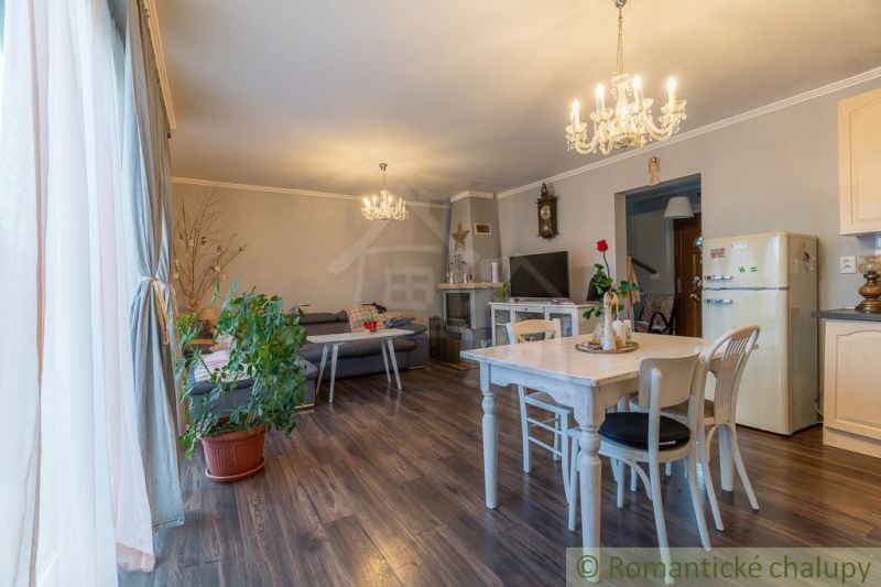 Interior of a family house with a wooden decor floor, dining table, and sofa set.