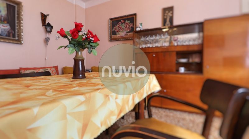 A dining room in a family house with wooden furniture and a table with flowers on a tablecloth.