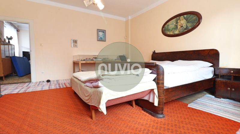 A bedroom with wooden furniture and a carpet in a family house.