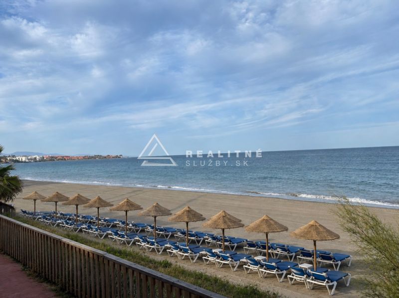 The beach at Dominion Beach in Estepona with sunbeds and umbrellas by the sea.