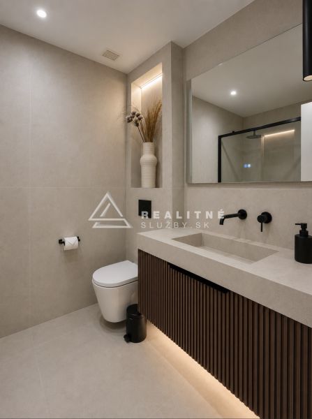 Bathroom with a shower and a sink with a mirror in a 4-room apartment.