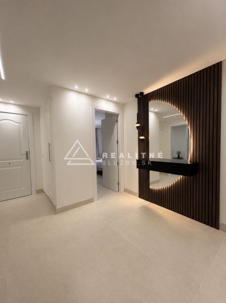 A hallway in a 4-room apartment, elegant furniture with lighting and design elements on the wall.
