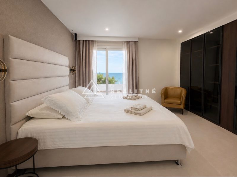 Bedroom in a 4-room apartment with a sea view, featuring a comfortable bed and a wardrobe.
