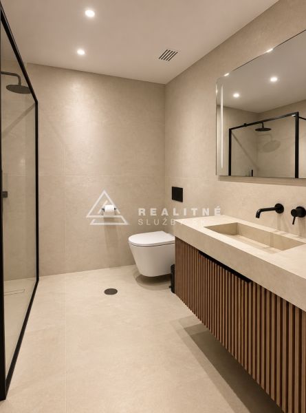 A bathroom in a 4-room apartment with a shower and wooden decor on the cabinet.
