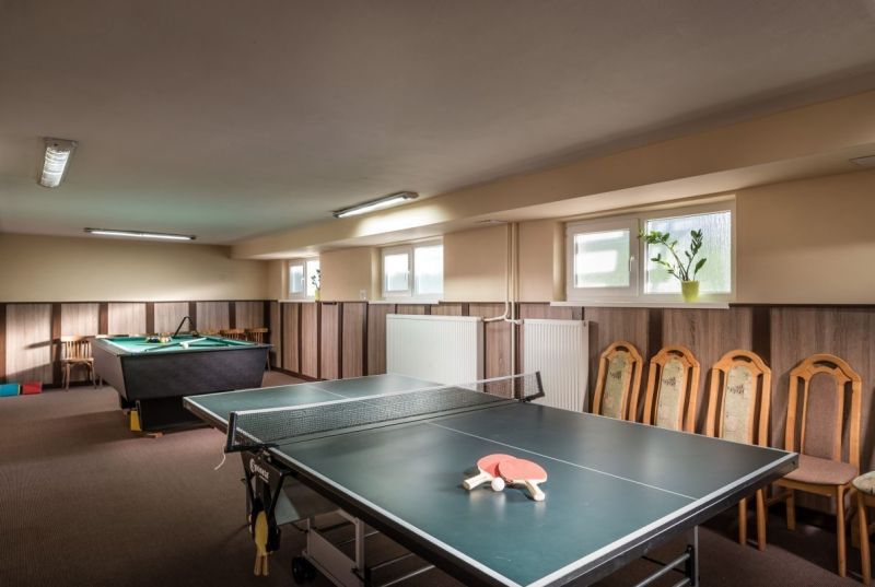 Ping pong and billiard table in the game room of hotels and guesthouses with wooden decor.