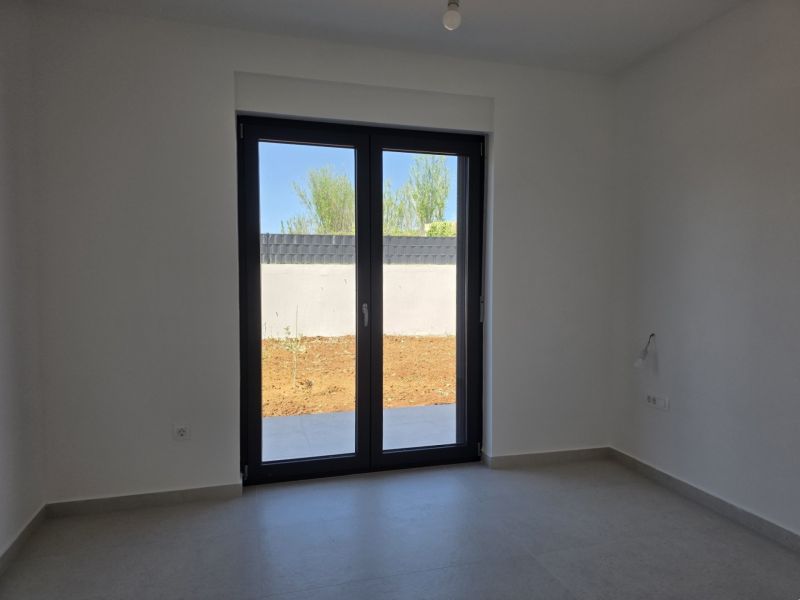 A room in a 4-room apartment with a large window and tiled floor.