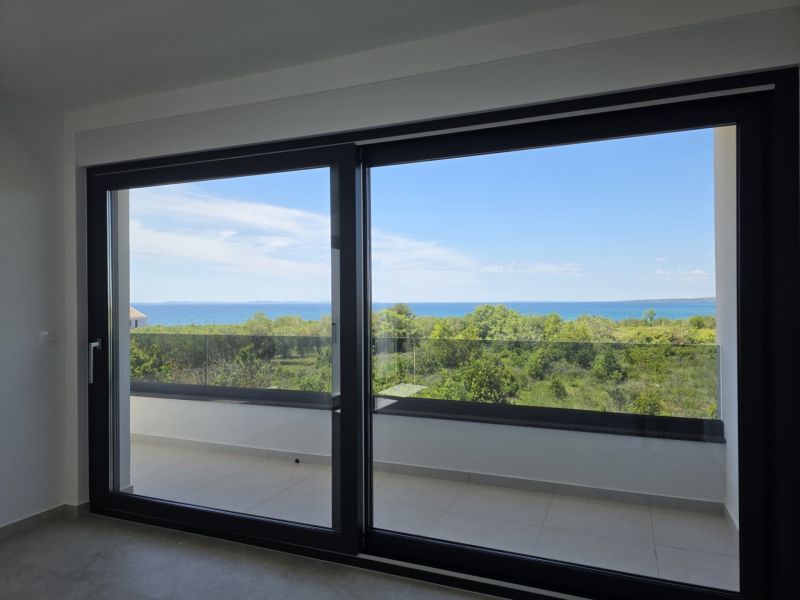 The large window in the 4-room apartment offers a panoramic view of nature and the sea.